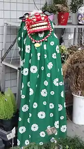 Photo couleur montrant un déguisement (une cape et un masque) pour la danse du lion.