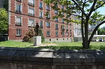 Une partie du jardin avec la statue en arrière-plan.