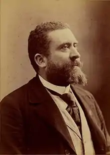 Photographie monochrome d'un homme barbu, de profil.