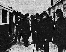 Photographie en noir et blanc d'un groupe d'homme discutant à côté de l'autorail Pauline, Jean-Raoul Paul porte un chapeau et une barbe blanche.