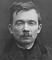 Photographie d'un homme portant une moustache.