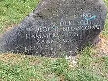 rocher gravé posé dans l’herbe d’un parc ;&nbsp;le texte indique les noms des villes jumelées