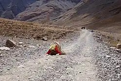 Pèlerin tibétain se prosternant de tout son corps tous les trois pas.