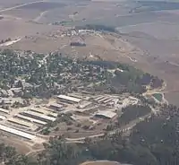 Vue aérienne de bâtiments sur une hauteur, au milieu des champs.