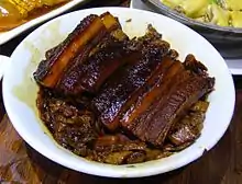 Tranches de porc et feuilles de moutarde (扣肉, kòu ròu).