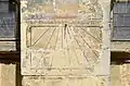 Cadran solaire quasi-méridional sur un contrefort de la façade avec la locution latine Vivens mortalis fugit umbra (Tout mortel passe comme l'ombre)