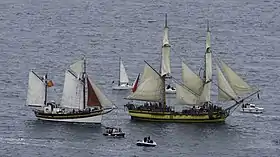 Photographie en couleurs de deux bateaux à voile à l’entrée du port de Sète.