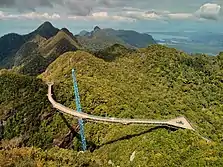 Pont suspendu au-dessus de petites collines typiques de l'Asie du Sud-Est.