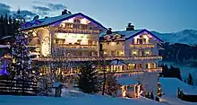 Vue de la façade de l'hôtel Le Chabichou sous la neige, de nuit.