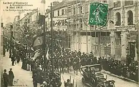 Le bâtiment en construction sur la droite, alors que le cortège du roi d'Espagne, Alphonse XIII, passe par la rue Grande, le 8 mai 1913.