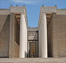 Photographie de l'entrée bordée de colonnes d'un bâtiment moderne.