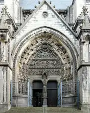 Photographie en couleurs du portail vu de face, de l'escalier jusqu'au haut du gable.