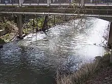 Un grand ruisseau de 4,5&nbsp;m de large, enjambé par un pont en béton (pas l'Antelope Creek Bridge), avec des tuyaux en métal en dessous. De la végétation éparse pousse sur les rives du ruisseau.