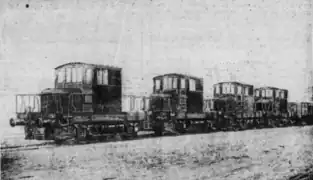 Photographie en noir et blanc de quatre locotracteurs se suivant.