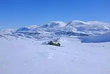 Montagnes arrondies dans un paysage enneigé.