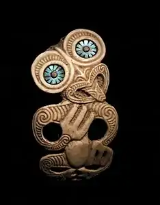 Pendentif hei tiki. Peuple Maori. Os gravé, nacre. H. 10&nbsp;cm. Nouvelle-Zélande. 1850-1950.