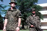 Deux Marines américains testent les premiers prototypes du MCCUU en 2001. Les deux prototypes sont dotés de manches amovibles, une caractéristique qui a été abandonnée par la suite sur la version de production finale. L'uniforme de gauche présente une première version du MARPAT woodland.