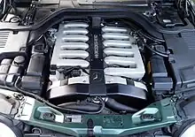 Photo du moteur V12 sous le capot d'une Mercedes-Benz 600 SEL, avec deux collecteurs d'admission à 6 branches.