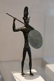Statuette en bronze d'un soldat avec une lance, un casque à crête et un bouclier.