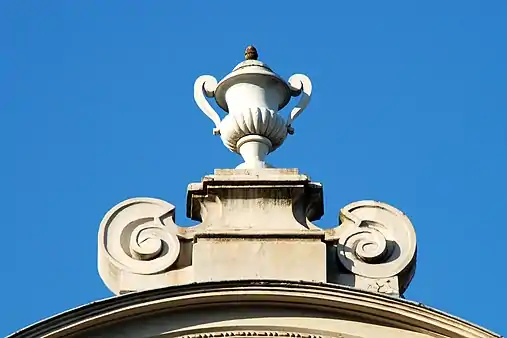 Le pinacle à volutes portant un vase de pierre.