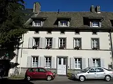 Maison blanche dans l'alignement des autres. Deux fenêtres de part et d'autre de la porte d'entrée, cinq au 1er étage, trois s'ouvrant dans le toit sur des chambres mansardées