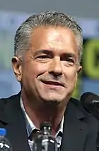 Photo d'un homme aux cheveux grisonnant qui sourit