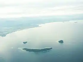 Une vue aérienne des îles de Mamutik (en haut à gauche), de Sulug (en haut à droite) et de Manukan (au centre) ressemblant à un visage souriant.