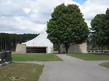 Le mausolée vu de l'axe principal du cimetière avec un arbre le masquant