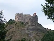 Photographie de ruines d'une forteresse sur une colline.