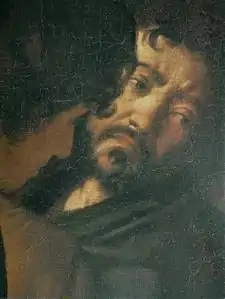 Visage d'un homme brun et barbu, qui regarde sur la droite, la tête penchée de côté et qui arbore une expression de tristesse.