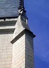 Vue d'un contrefort d'église surmonté d'une décoration de blasons.