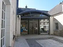 Photographie en couleurs d'un bâtiment moderne à la façade de verre.