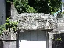 Photographie en couleurs d'une pierre sur laquelle se devinent des gravures partiellement effacées.