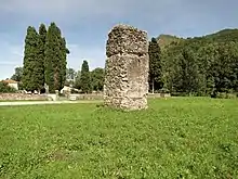 Photographie en couleurs d'un massif de maçonnerie dans un pré.