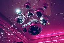 Photographie de boules à facettes suspendues à un plafond.