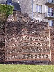 Vue d'une tour hexagonale en ruines et un édifice contemporain à droite