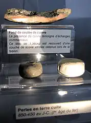 Fond de coulée de cuivre et perles de pierre.