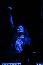 Image d'un homme au cheveux longs jouant du clavier et éclairée de bleu