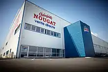 L'aspect d'architecture industrielle est donné par le bardage, très présent depuis la décennie 1960. Le bardage translucide en fibre de verre disponible au milieu du XXe siècle permet une nouvelle formulation de la couverture appuyée sur des portiques qui libèrent l'espace. Usine construite en 2009.