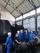 Un groupe d'anciens mineurs devant les machines.