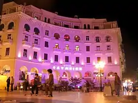 photographie couleurs : un grand bâtiment blanc éclairé de nuit de lumières violettes