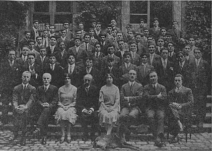 Photographie en noir et blanc de plusieurs rangées de personnes posant pour l'appareil photo.