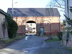 Grange du XIXe&nbsp;siècle en brique, sur le côté de l'église.