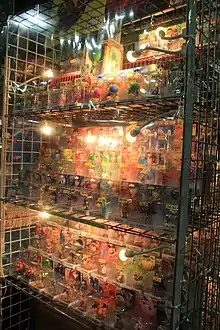 Plusieurs figurines sous emballage plastique sur une étagère.