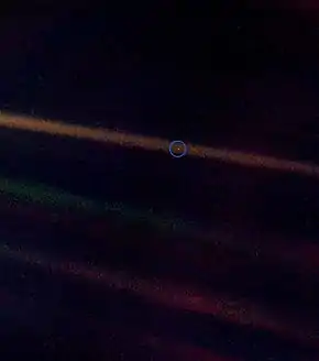 Fond noir barré de traits orangés ; un point est entouré en bleu.