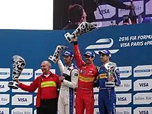 Photo de quatre hommes portant des trophées