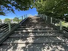 Marches sur la passerelle, le rail pour vélo étant visible à gauche.