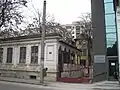 Maison bucarestoise du début du XIXe&nbsp;siècle (monument historique) avenue Șerban Vodă, devant un immeuble du début du XXe&nbsp;siècle, voisine d'un immeuble du XXIe&nbsp;siècle et sur fond d'immeubles des années 1960.