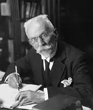 Photographie en noir et blanc du buste d'un homme en train d'écrire.