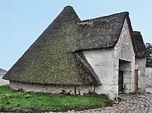 Photographie montrant un toit en forme de cône couvert de mousse.